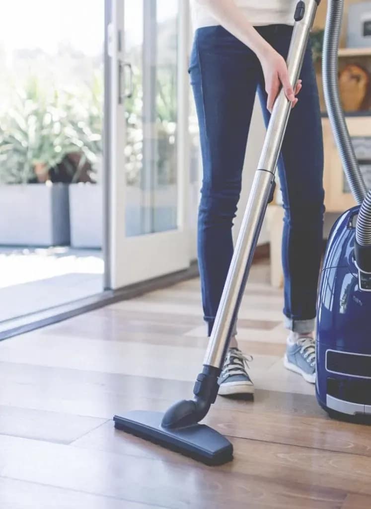 658afc1fb5e8da8b799c9686 A lady vacuum cleaning the floor